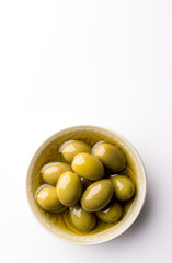 Fresh olives in a bowl on a white background. Copy space. Top view