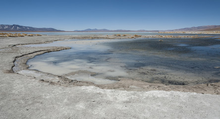 Laguna y Termas de Polques hot spring pool with Salar de Chalviri in background, Salar de Uyuni,...