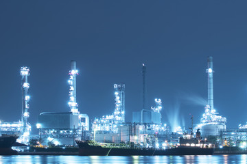 Obraz na płótnie Canvas Oil refinery with Chemical tanker ship is alongside at dusk.
