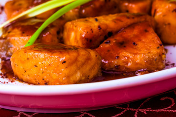 Salmon fillet in pomegranate sauce on white plate. Georgian cuisine
