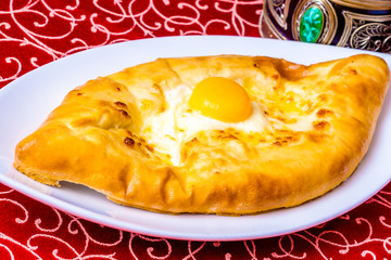 Ajarian khachapuri on white plate. Close-up