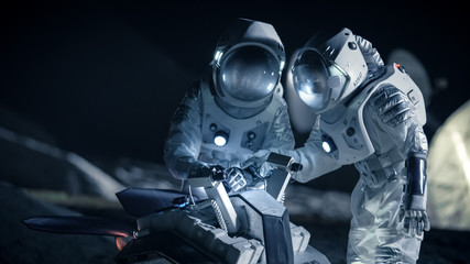 Two Astronauts in Space Suits on an Alien Planet Prepare Space Rover for Planet's Surface...