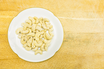 Plate with cashew nuts. View from above.