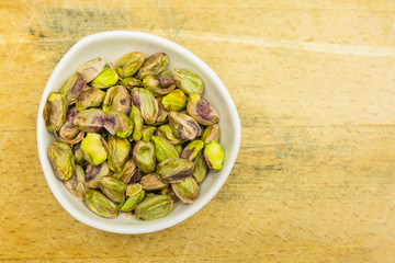 Bowl with shelled, roasted pistachios. View from above.