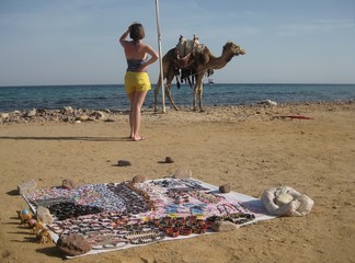 Dziewczyna z wielbłądem na plaży w Egipcie