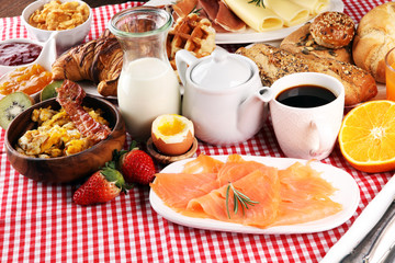 breakfast on table with waffles, croissants, coffe and juice