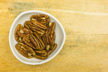 Bowl with shelled pecan nuts. View from above.