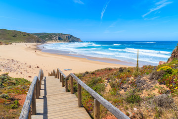 Fototapeta na wymiar Walkway to beautiful Praia do Amado beach, popular place to do water sports, Algarve, Portugal