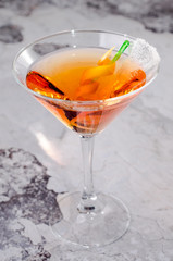 Top view red orange cocktail margareta fresh in a martini glass on a gray background. Bar alcohol drink menu, delicious tequila sunrise long drink for party.
