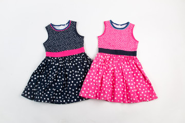 Elegant light children summer dresses. Pink and black on white dots