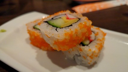 Sushi inside out with avocado, crab stick and omelette. Delicious sushi close up.