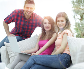 group of young people sitting on the couch in the living room.