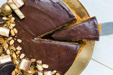 Delicious chocolate cake with biscuit, mousse layers, sweets and peanuts.