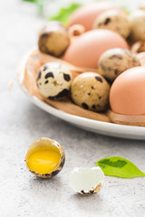 Festive Easter eggs in plate on concrete background. Selective focus, space for text.