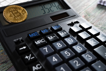 Bitcoin and keyboard calculator in a business office. Bitcoin golden coin New virtual money