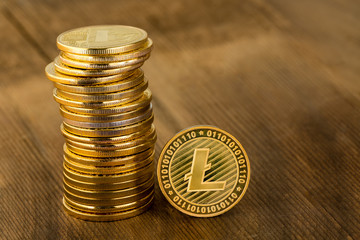 Single gold Litecoin coin alongside a stack