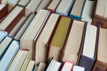 Many books in a bookstore or library on wooden background with copy space