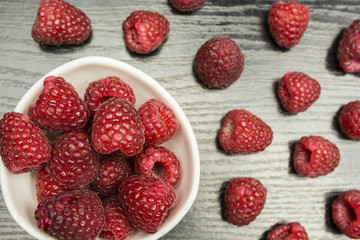 Top view of a table and a bowl of raspberries.