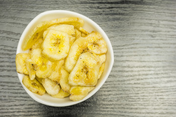 Bowl with dried banana chips. View from above.