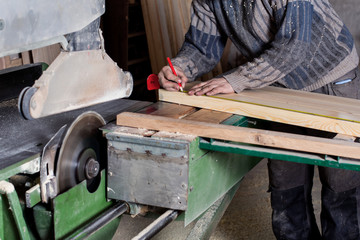 hand of a carpenter taking measurement of a wooden
