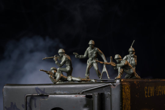 Toy soldiers with smoke behind them on ammunition can
