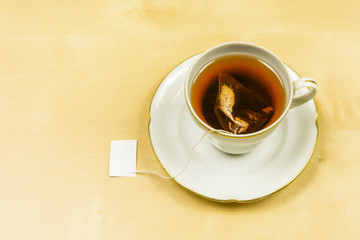 On the table a cup in which tea from a bag was brewed.