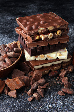 Chocolate bars on dark background with chocolate tower