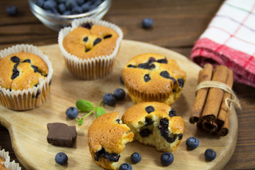 Muffins with blueberries, chocolate and cinnamon on a wooden board. Sweet dessert 