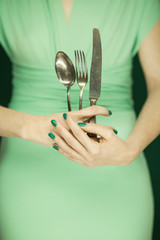 beautiful woman figure, bridesmaid in light green dress holding vintage cutlery, hands with green...