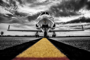 Farbschlüssel, kontrastreiches Schwarz-Weiß-Foto eines geparkten Business-Jets, der auf Passagiere wartet.