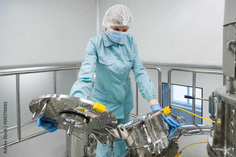 Canvas Prints pharmaceutical factory woman worker in protective clothing operating production line in sterile envi