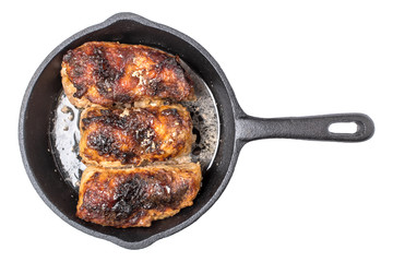 Roasted chicken pieces in cast iron pan top view, isolated