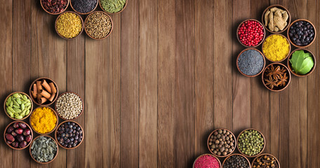 Spices on a wooden table, top view. Seasoning with empty space