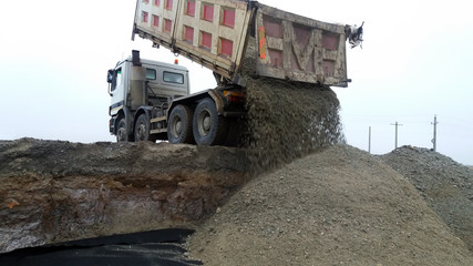 View of dump truck dumping gravel
