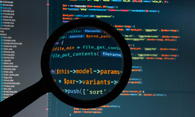 Php code under loupe on the screen of laptop