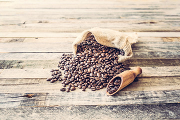 Roasted coffee beans in a bag on wooden background