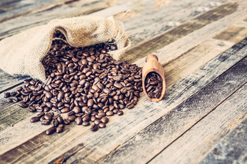 Roasted coffee beans in a bag on wooden background