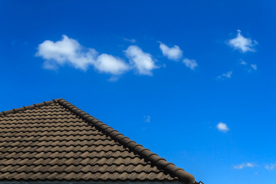 Old tile roof of house with fresh blue sky and white fluffy clouds in sunny day, Background for business target or meteorology presentation or construction site