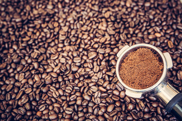 Espresso machine scoop on coffee beans background
