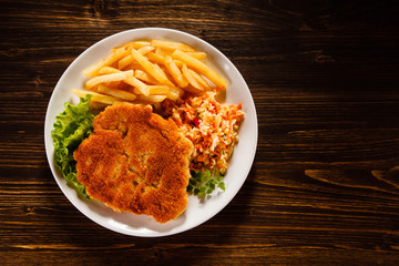 Fried pork chop, French fries and vegetable salad 