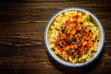 Pasta with tomato sauce and vegtables on wooden table 