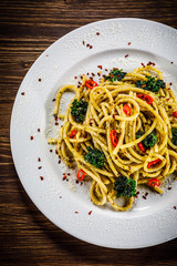 Pasta with collard on wooden table