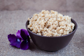 Boiled cereals quinoa in a deep plate on a linen tablecloth