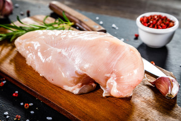 Raw chicken fillet on wooden table 