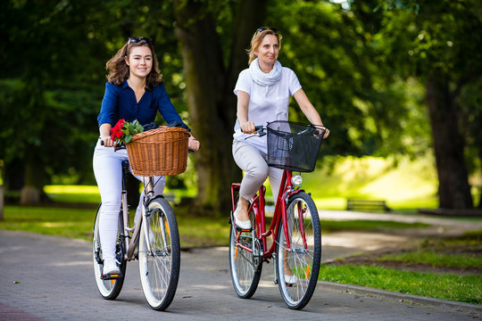 Women biking in city park 