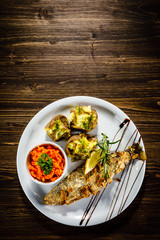 Fish dish - roast trout with almonds and vegetables on wooden table