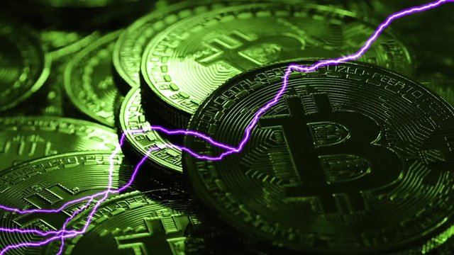 Blockchain technology, Bitcoins mining concept in green light with lightning, macro shot of bitcoins. Cryptocurrency Bitcoin, BTC, coins rotates in green light, power consumption concept