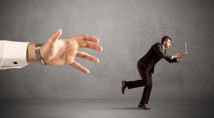 Businessman running from hand