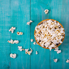 Popcorn explosion on blue background, Popcorn on blue top view copy space