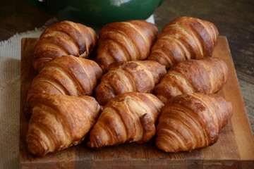 freshly baked croissants on wooden cutting board. Breakfast with croissants. 